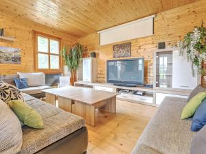 ein Wohnzimmer mit einem TV und einer Holzwand in der Unterkunft Detached wooden chalet in Liebenfels Carinthia near the Simonh he ski area in Liebenfels