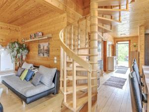 a living room with a spiral staircase in a log cabin at Detached wooden chalet in Liebenfels Carinthia near the Simonh he ski area in Liebenfels