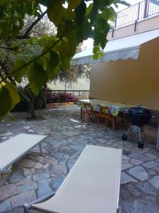 a grill and tables and chairs in a patio at Villino Bougainvillea in Voze