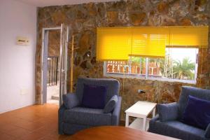 a living room with two chairs and a table and a window at Vivienda Vacacional Cuenca de Liria in Hermigua