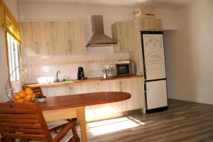 a kitchen with a table and a black and white refrigerator at Vivienda Vacacional Cuenca de Liria in Hermigua