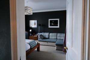 a living room with a blue couch and a chair at Llys Meddyg in Newport