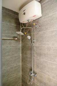 a shower with a shower head in a bathroom at Scent Bungalow - Village in Da Lat