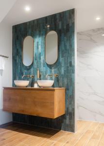 a bathroom with two sinks and two mirrors at Huisje Hartenlust in Bodegraven