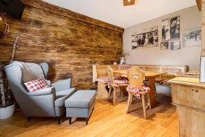 a dining room with a table and chairs and a wooden wall at Ferienhaus Annodazumol in Waischenfeld