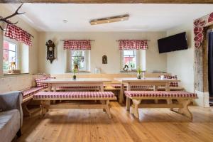 - un salon avec des tables, des bancs et des fenêtres en bois dans l'établissement Ferienhaus Annodazumol, à Waischenfeld