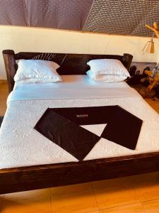 a bed with a wooden frame and two pillows on it at GOOD MOOD BEACH RESORT LTD in Rwamagana
