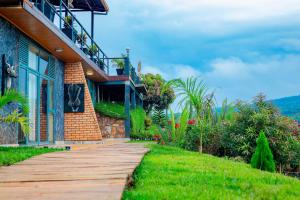 a house with a wooden walkway in front of it at GOOD MOOD BEACH RESORT LTD in Rwamagana