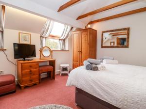 a bedroom with a bed and a tv and a desk at Granary Studio in Gloucester