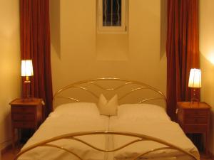 een slaapkamer met een bed met 2 nachtkastjes bij Villa Schlössle in Badenweiler