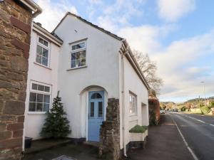 a white house with a blue door on a street at Granary Studio in Gloucester