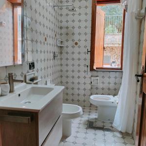 baño con lavabo y aseo y ventana en Camera Relax confortevole e riservata in villa, en Massa Lubrense