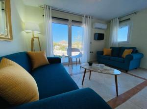 - un salon avec un canapé bleu et une table dans l'établissement The Blue House, à Vromolithos