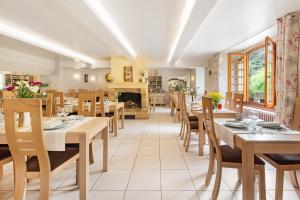 comedor con mesas y sillas y chimenea en Hôtel Restaurant Le Relays du Chasteau - Logis Hôtel en Brousse-le-Château