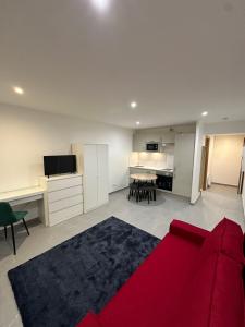 uma sala de estar com um sofá vermelho e uma cozinha em ARC Montgeron em Montgeron
