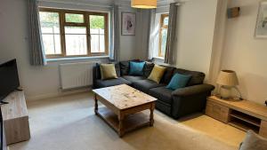 a living room with a couch and a coffee table at Modern 4 Bed Detached Private House-Parking-Garden in Down Hatherley