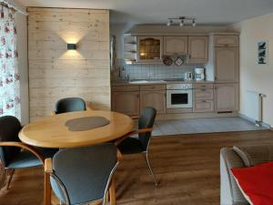 a kitchen and dining room with a wooden table and chairs at Ferienwohnung Grüner in ruhiger, zentraler Lage von Burgberg im Oberallgäu in Burgberg