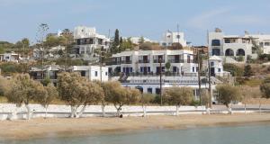 una playa con árboles y edificios en el fondo en Aphroditi Hotel, en Lipsi