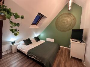 um quarto com uma cama e uma televisão em Le Nid Douillet - Hypercentre - Studio em Beauvais