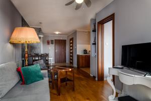 a living room with a couch and a television at Apartament Stonehaven in Jastrzębia Góra