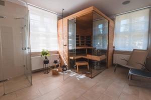 baño con ducha de cristal, mesa y silla en Theresian Apartment, en Ostružná