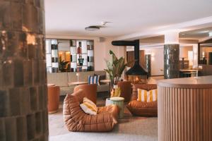 a lobby with couches and chairs in a building at Hotel Enzian - Adults Only in Obertauern