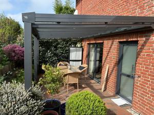 a black pergola on the side of a brick building at Apartment Hideaway in Bad Oeynhausen