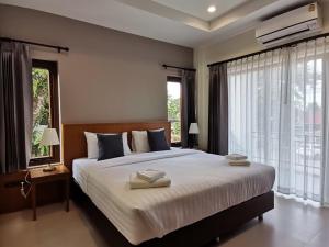 a bedroom with a large bed with two towels on it at Pak Ping Rim Khong in Chiang Saen