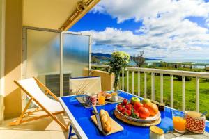 - une table bleue avec un plateau de fruits sur un balcon dans l'établissement SELECT'soHOME - Studio pour 2 personnes sur la plage du Lavandou avec parking privé ! - FREGATE-04, au Lavandou