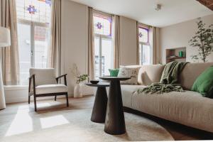 uma sala de estar com um sofá e uma mesa em The Guest Apartments - Lange Putstraat em Den Bosch