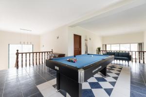 a living room with a pool table on a checkered floor at GuestReady - Quinta do Sol in Mealhada