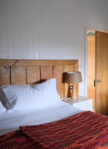 a bedroom with a large bed with a wooden headboard at Llys Meddyg in Newport