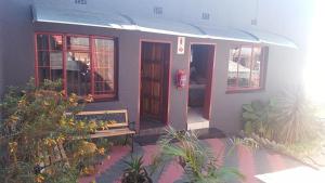 a small house with a bench in front of it at Nthateng Bed and Breakfast in Soweto