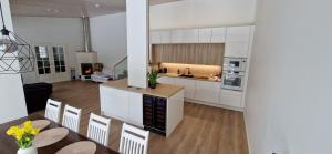 a kitchen with white cabinets and a table and chairs at Uusi omakotitalo nyt saatavilla! in Kerava