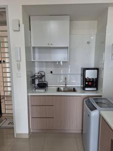 uma cozinha branca com um lavatório e um micro-ondas em Affordable Residence Plaza @ KJ em Petaling Jaya