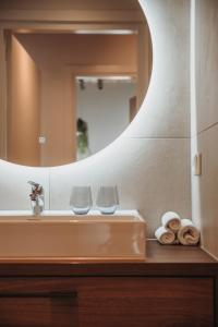 een wastafel in de badkamer met 2 glazen en een spiegel bij The Guest Apartments - Lange Putstraat in Den Bosch