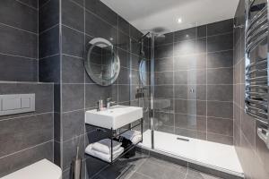 a bathroom with a sink and a shower at Appart'City Collection Paris Roissy CDG Airport in Roissy-en-France