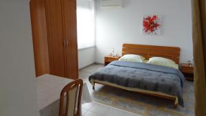 a bedroom with a bed and a table at Apartment Rosabela in Primošten
