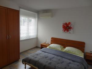 a bedroom with a large bed and a window at Apartment Rosabela in Primošten