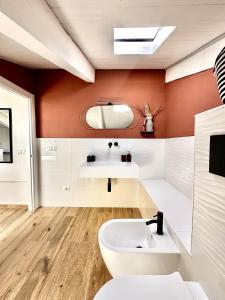 y baño con lavabo blanco y paredes de color naranja. en Domus Traiano - Luxury Port Apartment, en Civitavecchia