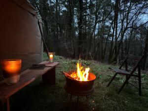 un braciere seduto accanto a un tavolo e a una panchina di Sweet Hill Eco Fort a Exeter