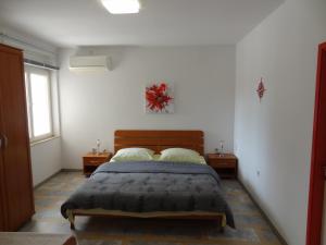 a bedroom with a bed and two night stands at Apartment Rosabela in Primošten