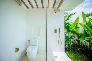 ein Bad mit einem WC und einer Glasdusche in der Unterkunft The Putih Tiny Villa - Stylish Mezzanine Loft 5mins to Nyanyi Beach in Tanah Lot