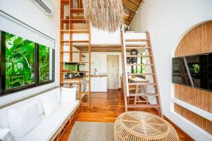 ein Wohnzimmer mit einer weißen Couch und einer Leiter in der Unterkunft The Putih Tiny Villa - Stylish Mezzanine Loft 5mins to Nyanyi Beach in Tanah Lot