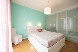 a bedroom with a white bed and a white chair at Sweet Home Padenghe in Padenghe sul Garda