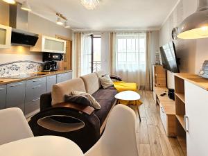 a living room with a couch and a kitchen at visit baltic - Kwartał Róży Wiatrów apartament SK30 z parkingiem in Świnoujście