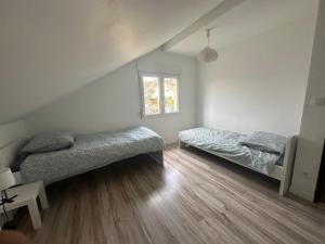 1 dormitorio con 2 camas y ventana en Maison familiale avec vue dégagée, en Vaux-lès-Prés