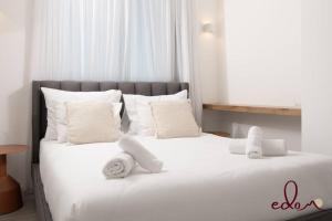 a bedroom with two beds with white sheets and pillows at דירת 2 חדרי שינה עם נוף מדהים לים - By Edomlux in Eilat +20 photos