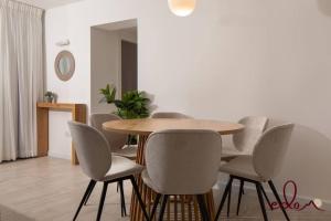 uma sala de jantar com uma mesa de madeira e cadeiras em דירת 2 חדרי שינה עם נוף מדהים לים - By Edom em Eilat