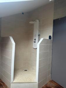 y baño con ducha y cabezal de ducha. en Maison familiale avec vue dégagée, en Vaux-lès-Prés